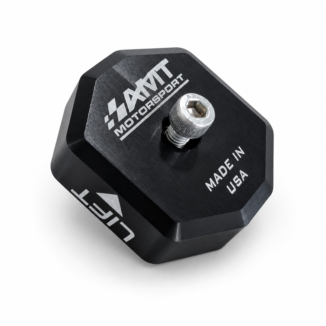 Black anodized AMT Switchblade jacking puck showing a center screw, AMT logo on the contact face and LIFT engraving on the side