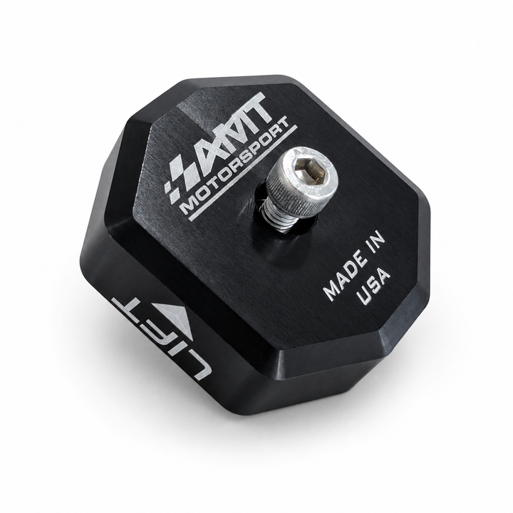 Black anodized AMT Switchblade jacking puck showing a center screw, AMT logo on the contact face and LIFT engraving on the side
