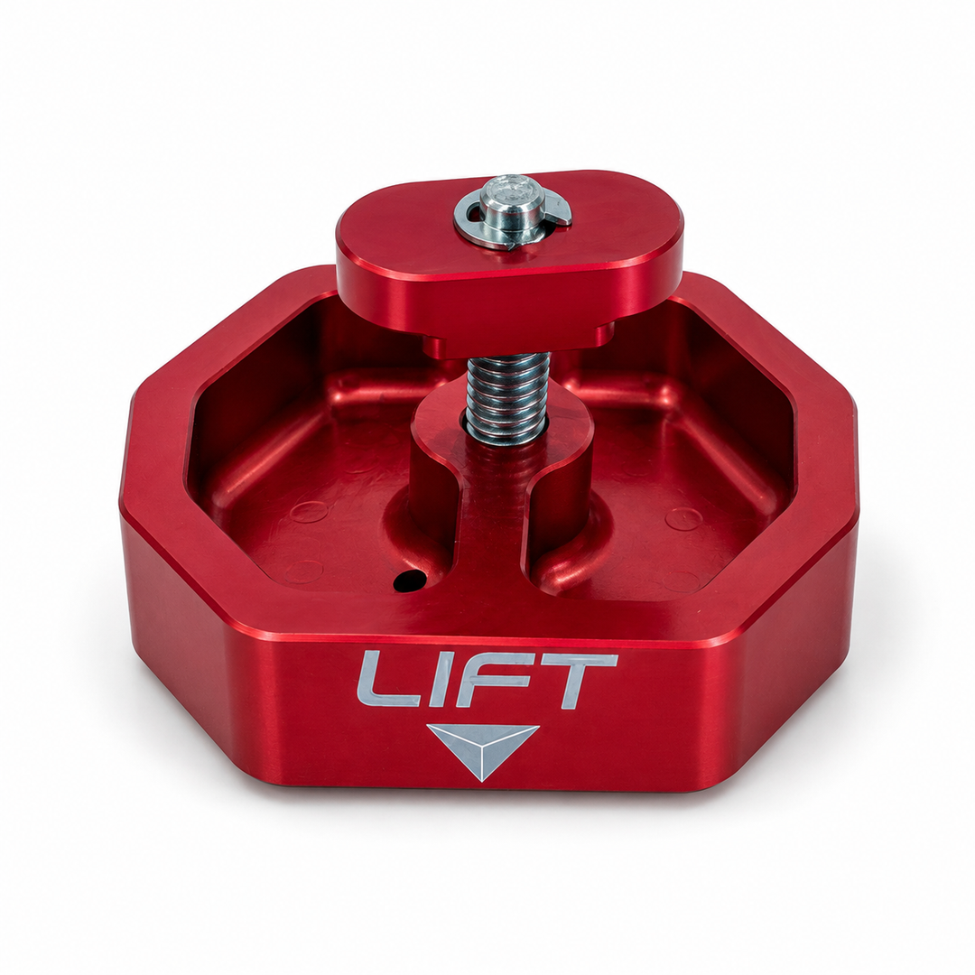 Red AMT Switchblade jacking puck viewed from above its pocketed body, showing the threaded screw and captive retaining plate