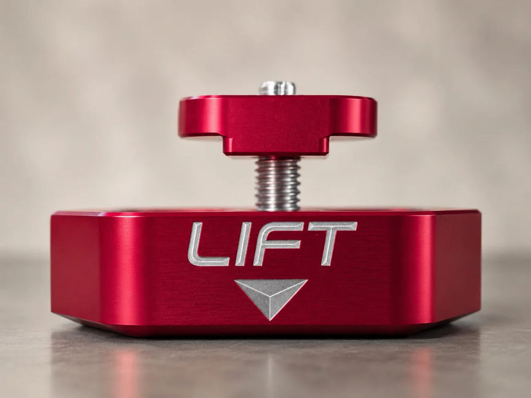 Side view of a red AMT Switchblade jacking puck showing the body profile, engraved LIFT marking and raised retaining plate above it