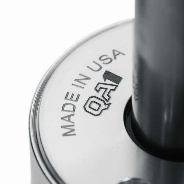 Close-up of a shock with 'Made in USA QAI' engraving on a white background