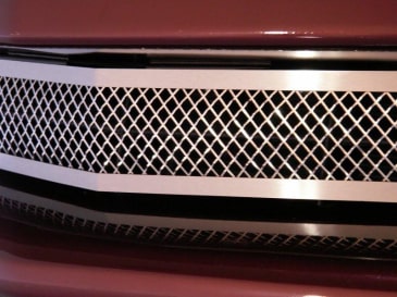 Front close-up of American Car Craft 042041 polished Laser Mesh grille on a red C6 Corvette Base