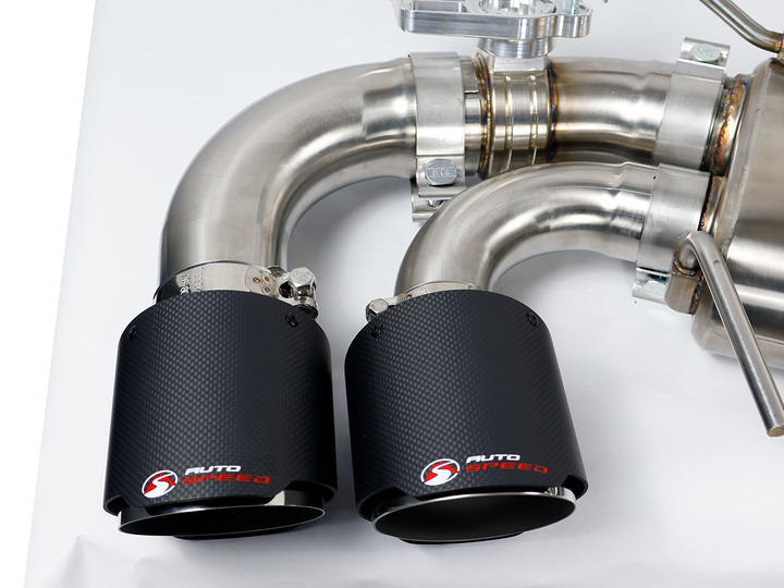 Driver side muffler and outlet of the AutoSpeed C8 Corvette cat-back with carbon fiber tips, on a studio table