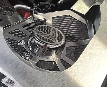 Angled view of the early C8 Corvette Coupe carbon-fiber shock-tower cover and C8 emblem cap, with surrounding engine trim shown