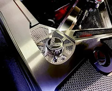 ACC 883031 perforated stainless shock-tower insert with a carbon-fiber C8 emblem cap top in an early C8 Corvette Coupe engine bay