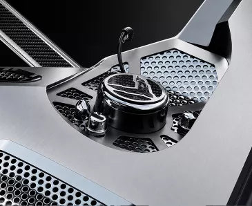 ACC 883070 perforated stainless shock-tower insert with a C8 crossed-flag cap in a 2023–2026 Corvette Coupe engine compartment