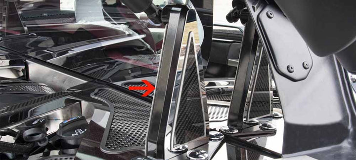 Side view of polished stainless and carbon-fiber C8 Corvette Coupe hinge trim, with an arrow identifying the dress-up accent