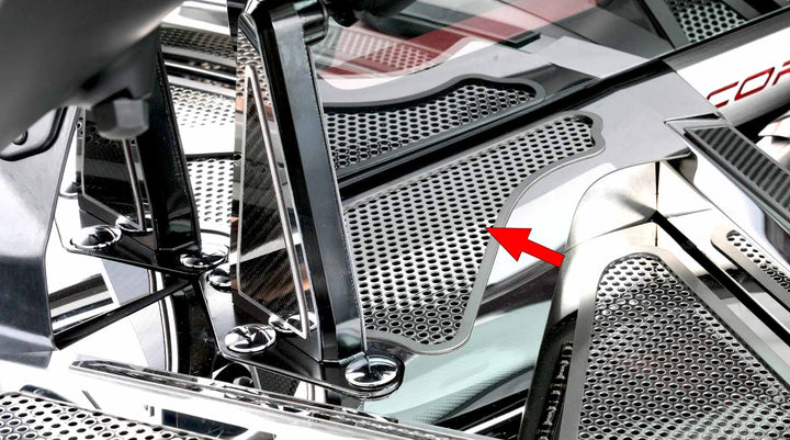 Opposite-side view of the perforated stainless cowl cover in a C8 Corvette Coupe engine bay, with an arrow marking the trim location