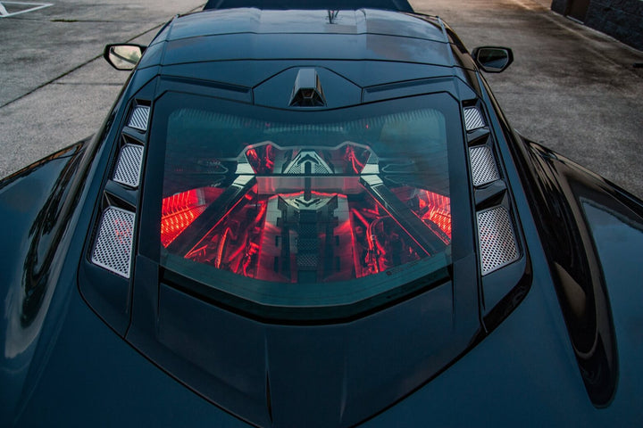 C8 Corvette Coupe rear hood with polished vent inserts on both sides of the window and separate engine accessories visible