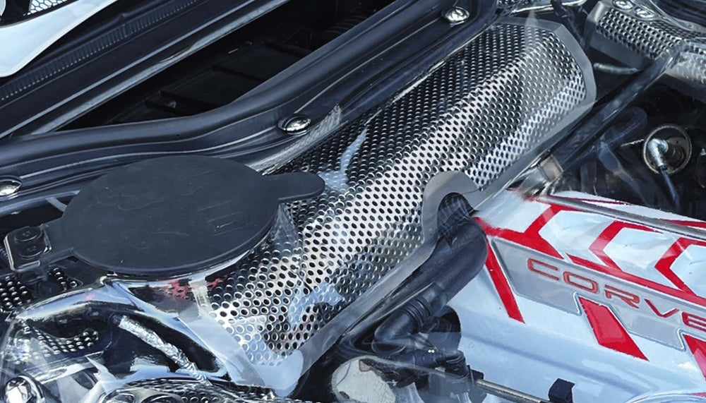 Close view of the perforated water tank cover beneath a clear C8 convertible engine-bay cover