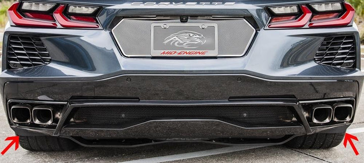 Rear view of a C8 Corvette with arrows marking both carbon-fiber-wrapped rear mud guards; other rear accessories are shown