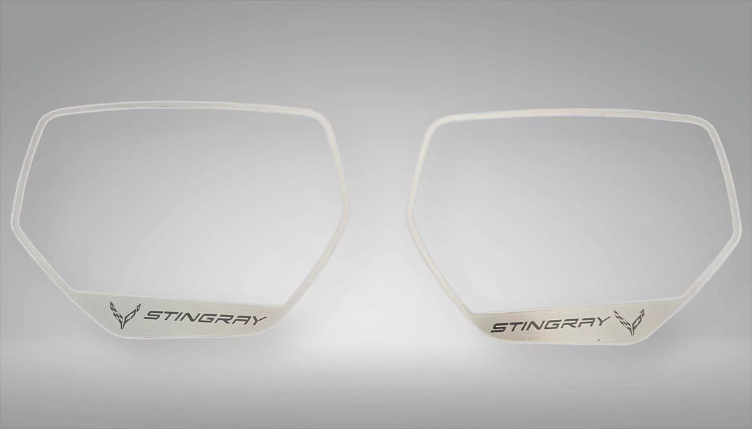 Two brushed stainless side-mirror trim frames with STINGRAY lettering and C8 logos