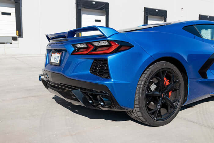 CORSA Black PVD quad exhaust tips in the rear diffuser of a blue C8 Corvette Stingray, three-quarter rear view