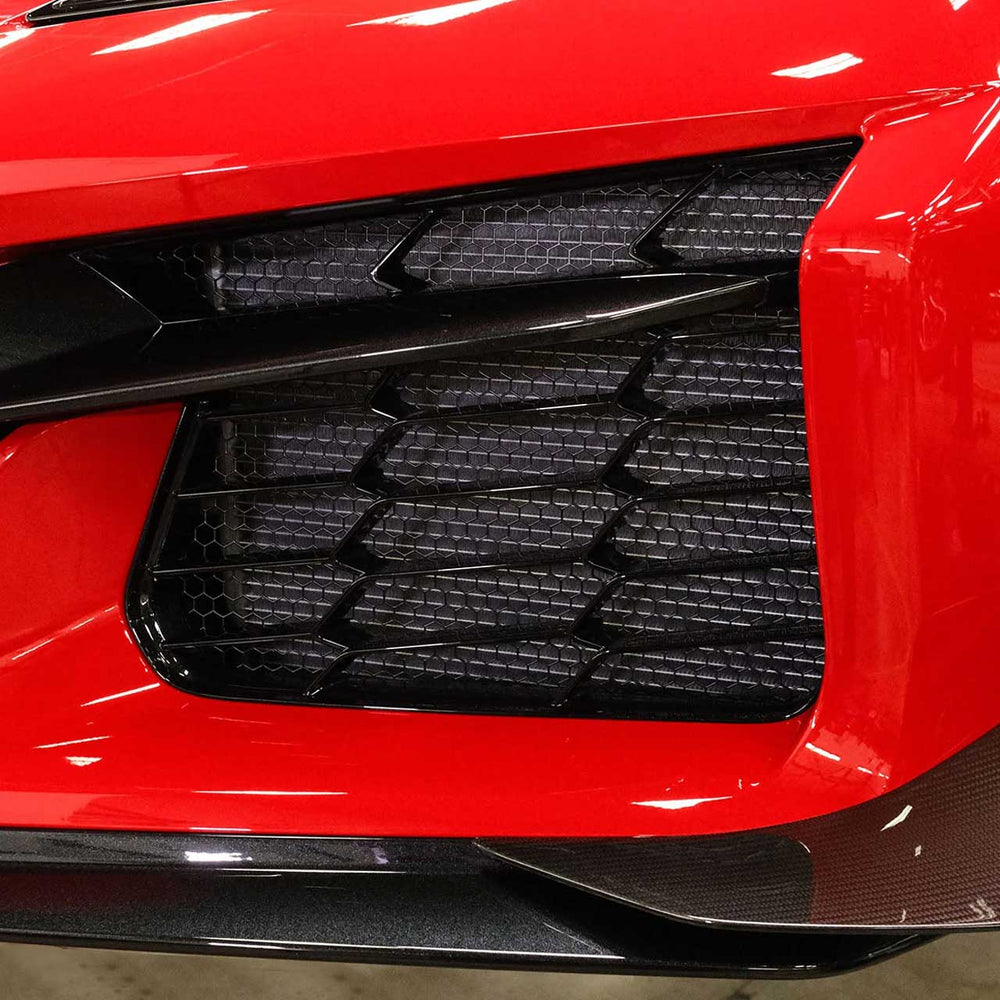 Close-up of ACS Composite radiator guard mesh behind Z06 front grille, black powder-coated stainless design.