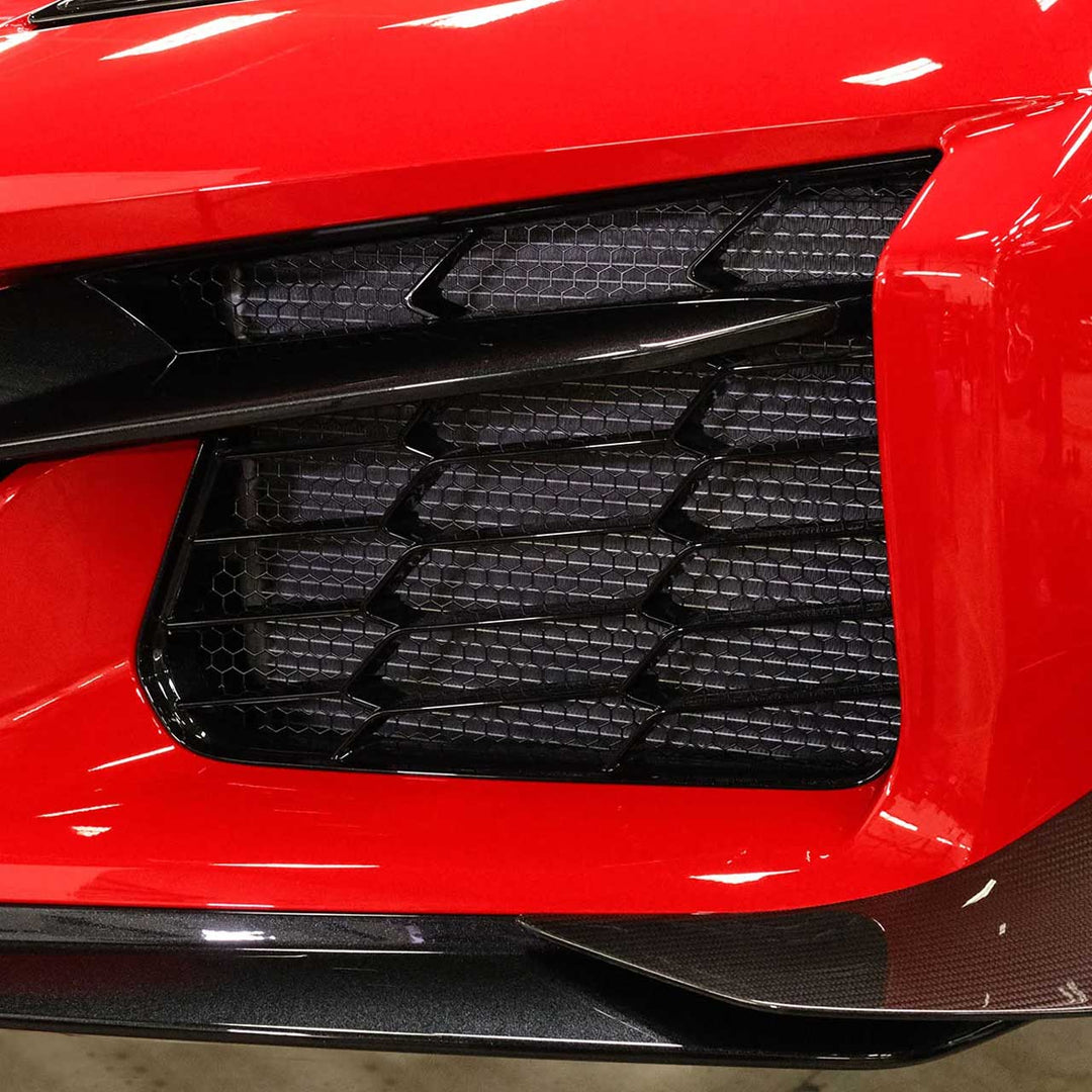 Close-up of ACS Composite radiator guard mesh behind Z06 front grille, black powder-coated stainless design.