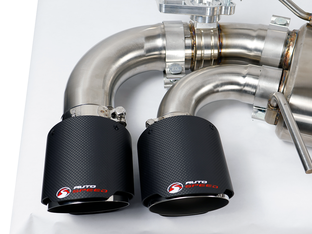Driver side muffler and outlet of the AutoSpeed cat-back with carbon fiber tips, on a studio table