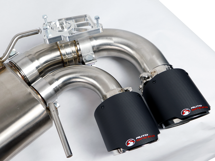 Passenger side outlet pipes of the AutoSpeed cat-back with carbon fiber tips, on a studio table