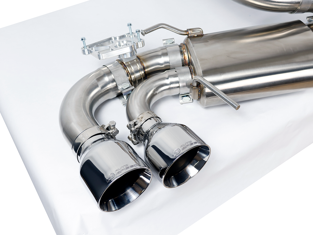 Driver side muffler and outlet of the AutoSpeed cat-back with polished stainless tips, on a studio table