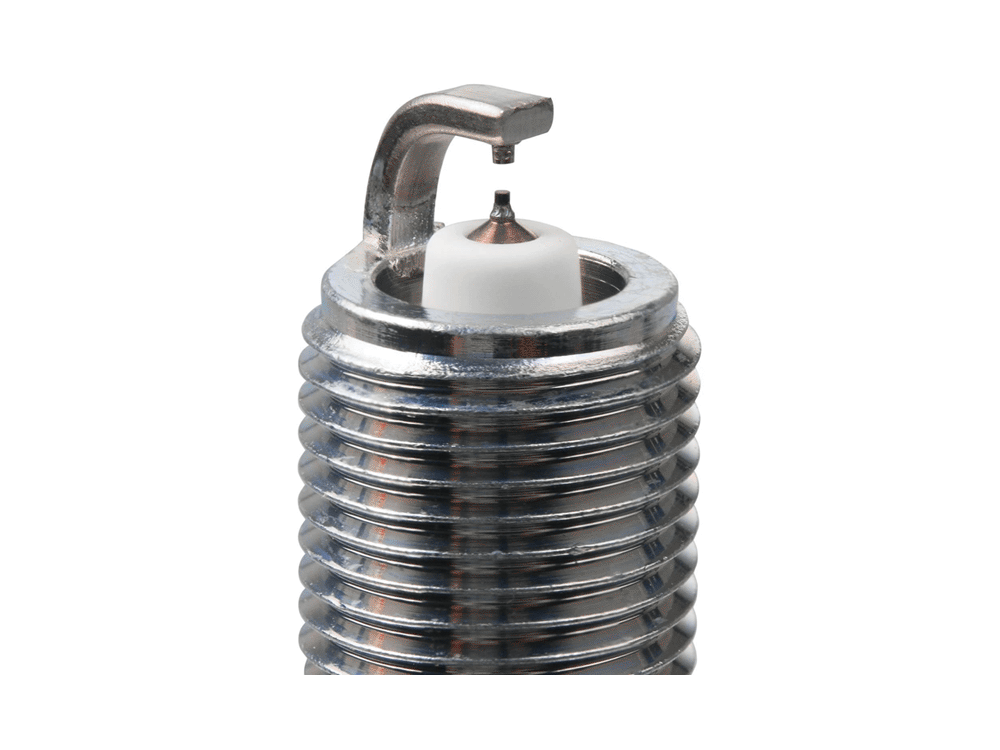 NGK Ruthenium HX spark plug electrode close-up showing the fine center tip, curved ground electrode and threaded metal shell